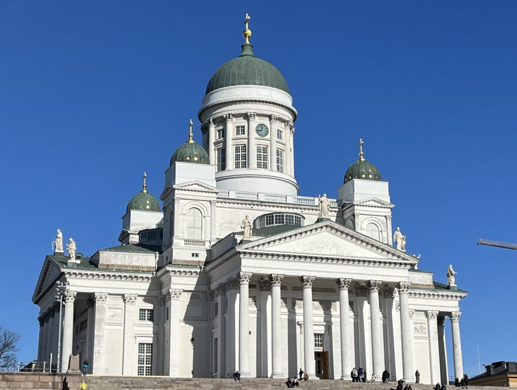 Image of Helsinki Cathedral in Helsinki, Finland. The sky is bright blue and the sun is shining over the monument.