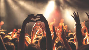 Fans making a heart with their hands at a concert