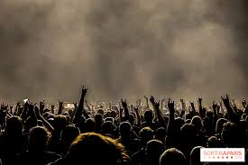Concert crowd with raised hands and smoke at a live show